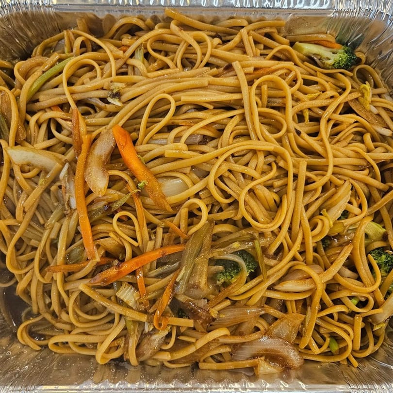 Close-up of Ho Mei Express Chinese Kitchen's lo mein noodles with vegetables in a foil container.