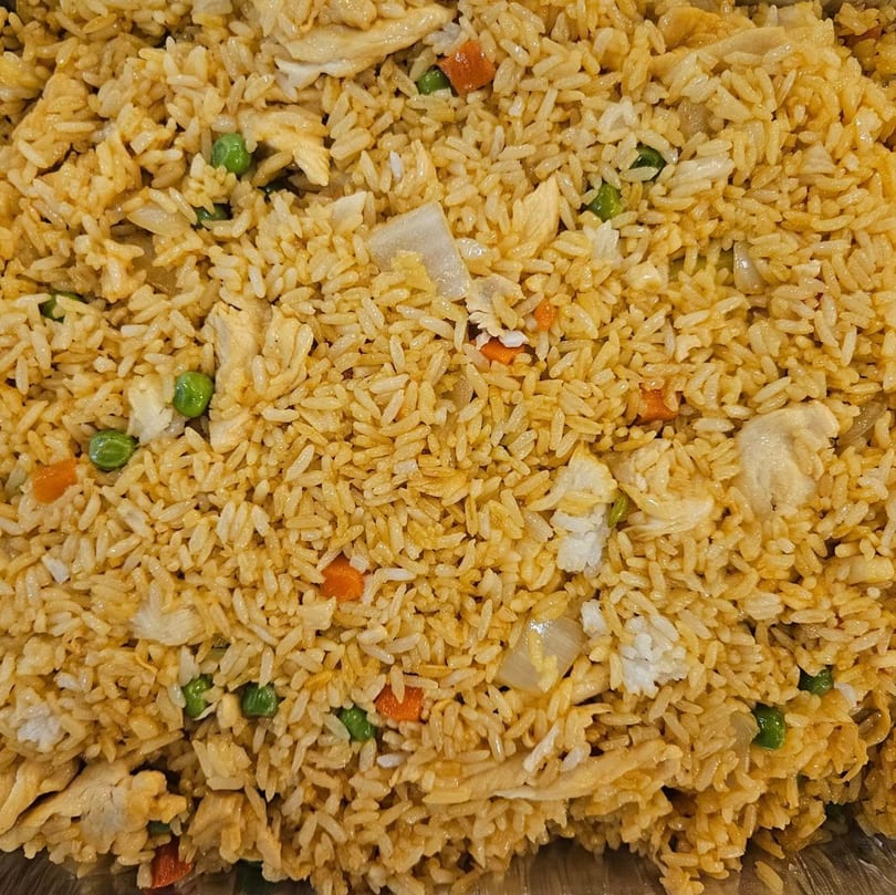 Close-up of Ho Mei Express chicken fried rice with peas, carrots, and onions.